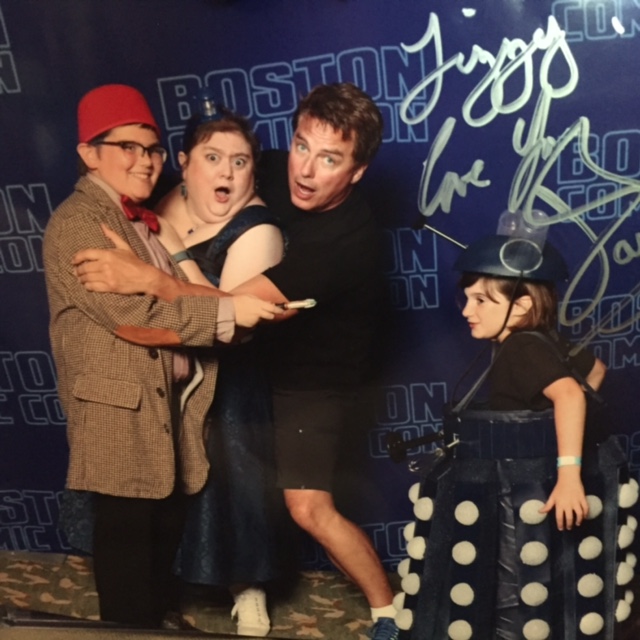 family posing with john barrowman at comic-con