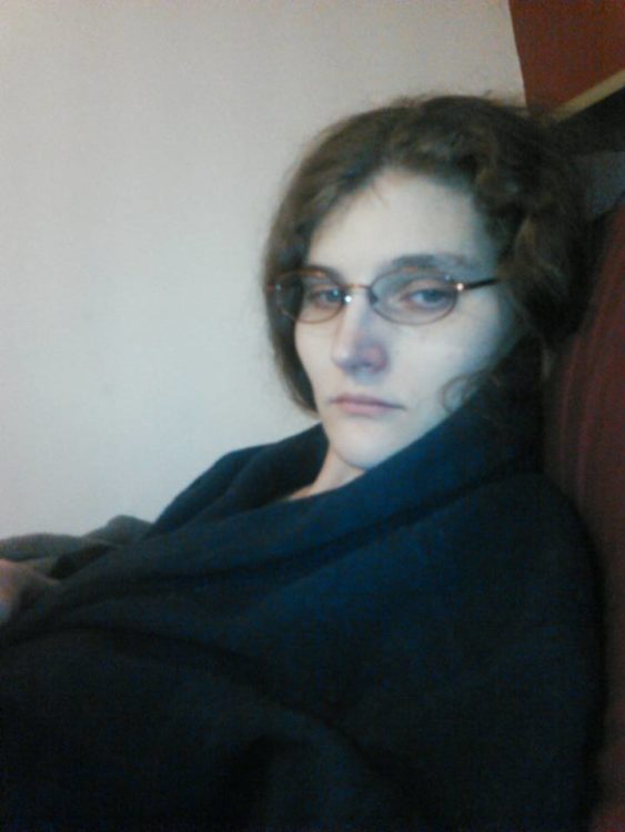 woman wrapped in a blanket and feeling sick