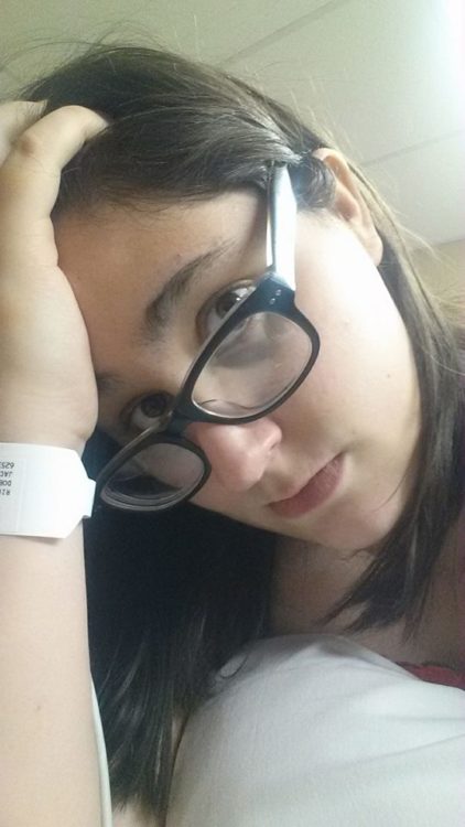 woman wearing glasses and a hospital bracelet