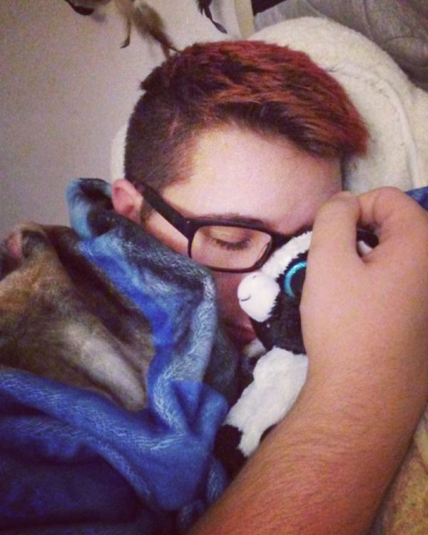 man lying in bed with his blanket and stuffed animal