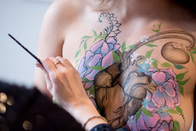 woman having her body painted