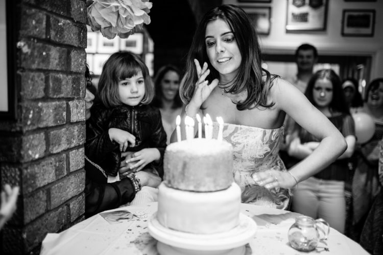 woman blowing out birthday cake candles