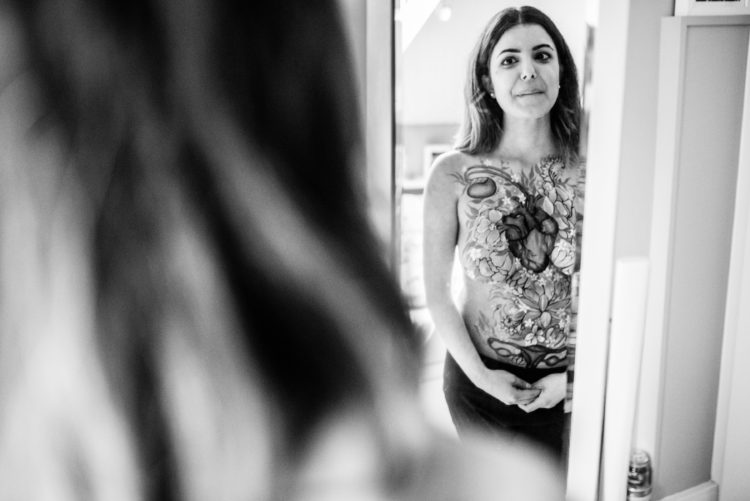 woman standing in front of a mirror with her body painted