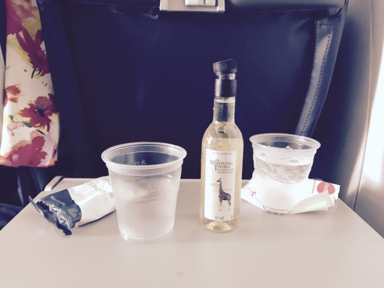 celebrating with a drink on the plane