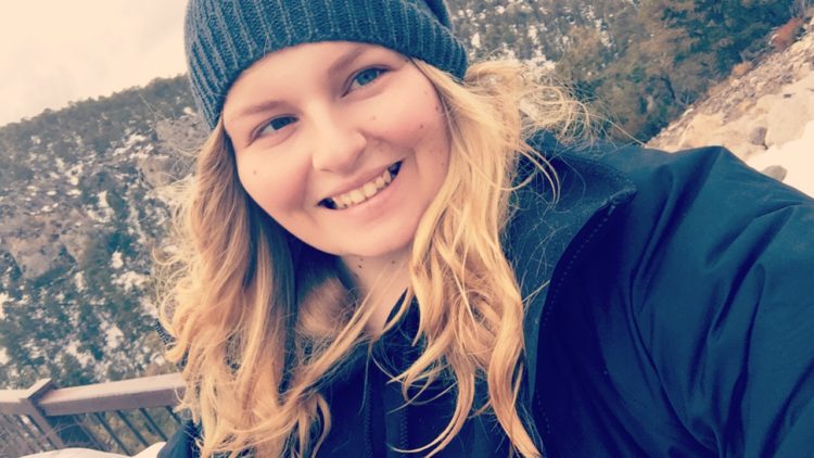 woman wearing a coat and beanie outside on a snowy day