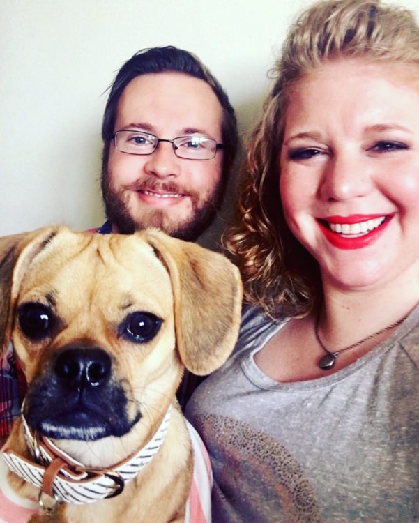 woman smiling with her fiance and dog
