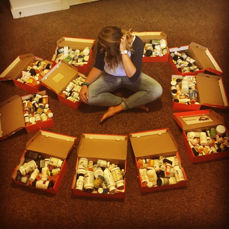 Sadie Williams poses with her Nike shoe boxes full of empty prescription and supplement bottles she has collected over the past 3 years of her fight against Lyme.