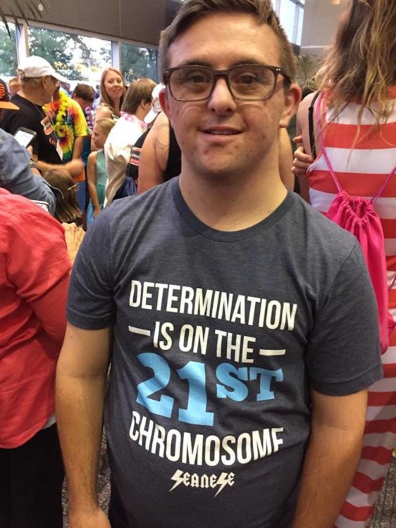 Sean wearing one of his shirts that reads, "Determination is on the 21st chromosome"
