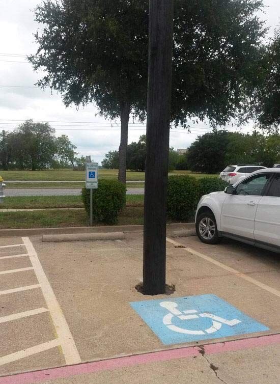 Supposed disability parking space with a pole through the middle. 