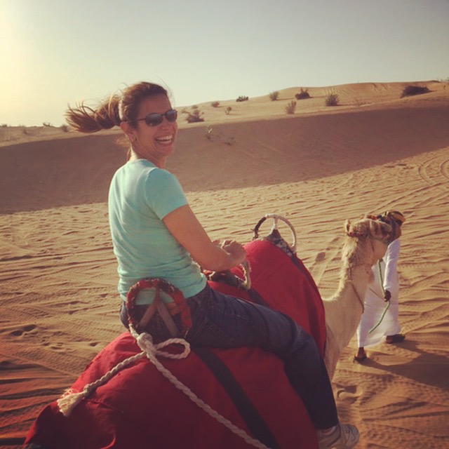 Riding a camel in the desert.