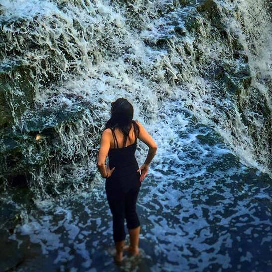 The writer standing in front of a waterfall.