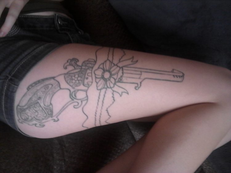 tattoo of a pistol on a woman's leg