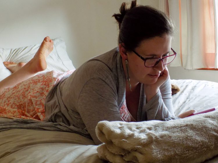 woman reading a book on her kindle in bed