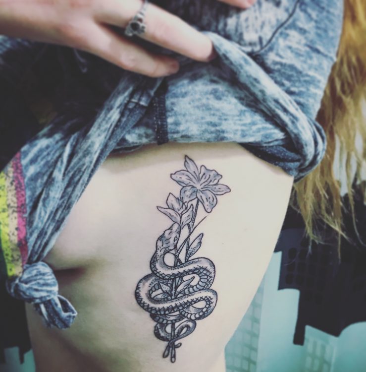 snake and roses tattoo on woman's rib