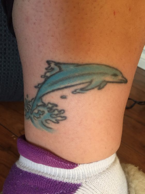 tattoo of a dolphin on woman's ankle