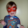 boy wearing red mask and cape and superman shirt