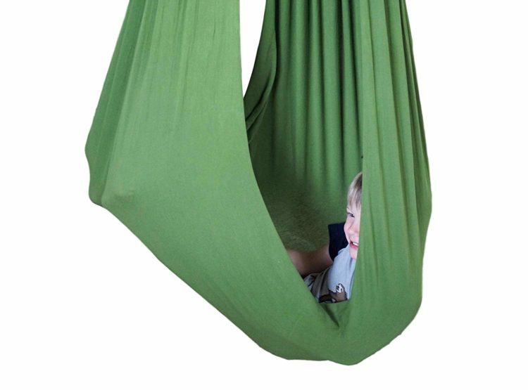 green therapy swing made of fabric with child sitting inside