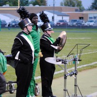 students perform in band on sidelines of football game