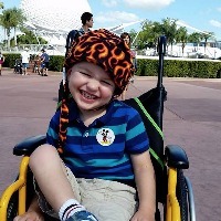 author's son sitting in his wheelchair and smiling