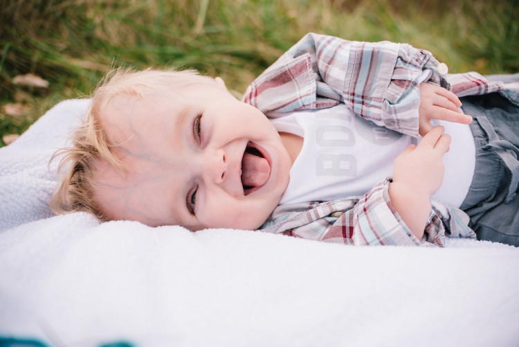 baby boy laying outside laughing