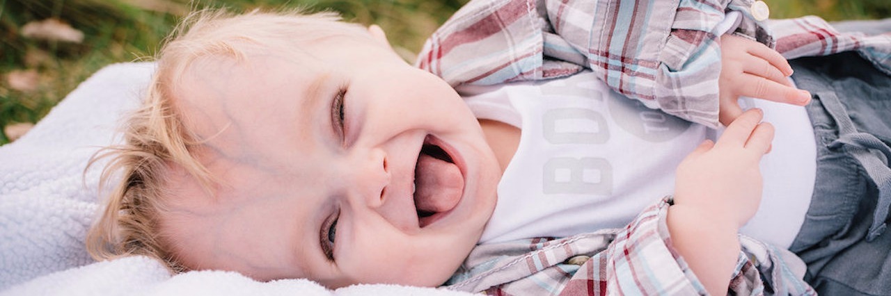 Learning Your Unborn Baby's Condition May Be Lethal baby boy laying outside laughing