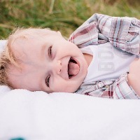 baby boy laying outside laughing