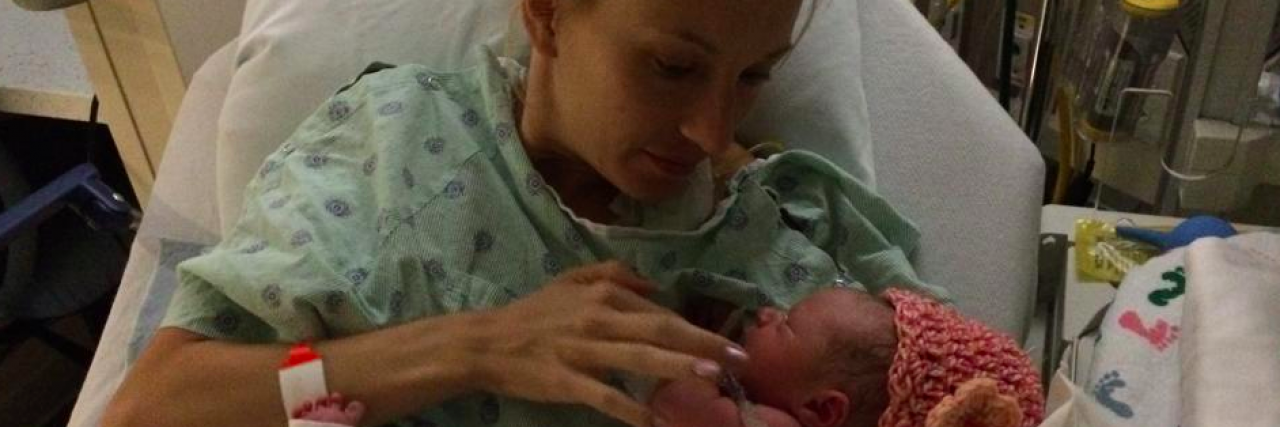 Mom Writes Letter to Mothers Upset Over Babies' Spina Bifida Diagnosis Contributor in hospital bed and gown holding baby with tubes and wires attached