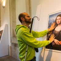 man touching 3-D painting of the mona lisa
