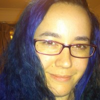 A woman with purple hair and glasses