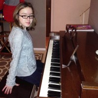 A young girl with glasses at the piano