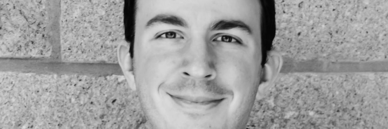 Man Addresses His Dysferlinopathy black and white photo of man wearing jacket and button-down shirt