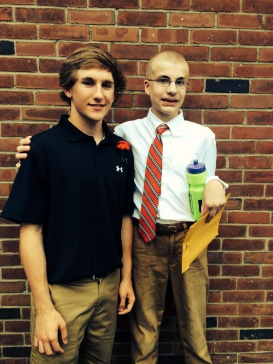 two boys standing in front of brick wall