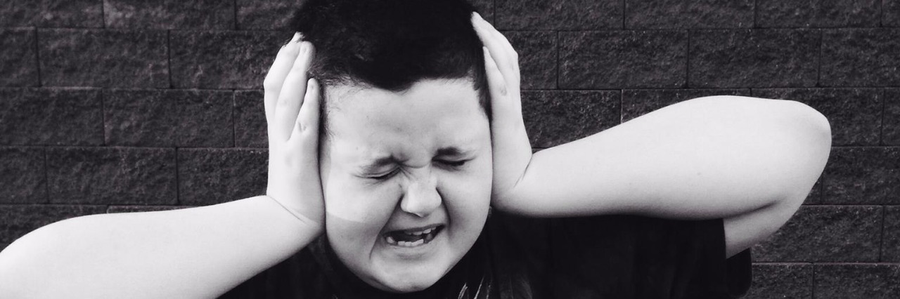 What Parents of Kids With Apraxia of Speech Wish You Wouldn't Say boy with hands on either side of his head