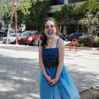 A girl in a dress smiling for camera