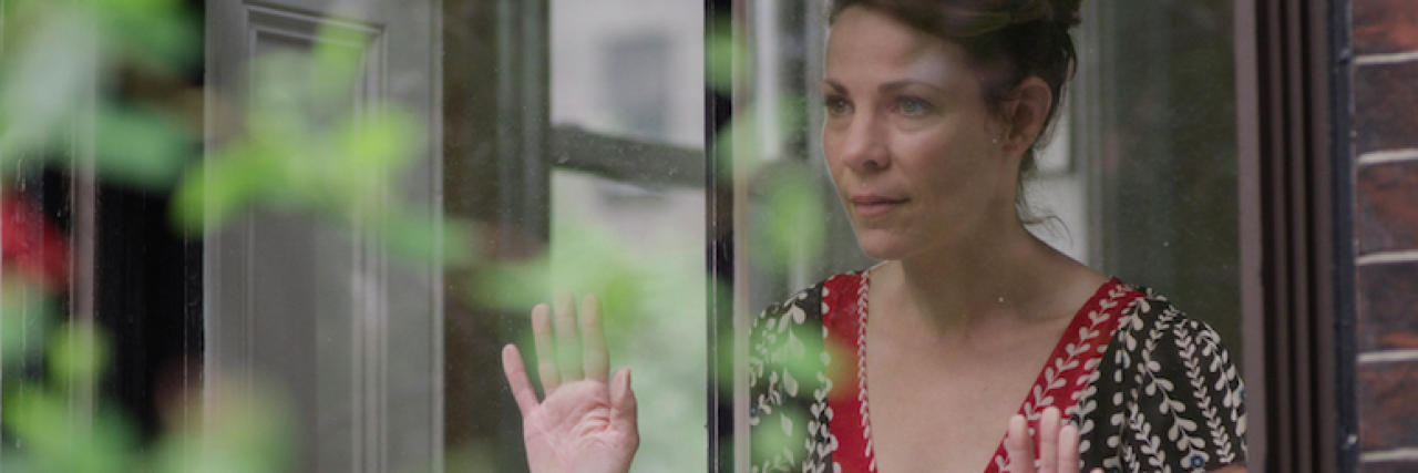 Film 'A Woman Like Me' Follows Life of Woman With Breast Cancer Actress Lili Taylor holding her hands against and looking out window
