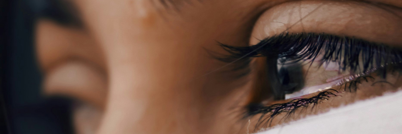 A close up of a woman's brown eyes full of tears.