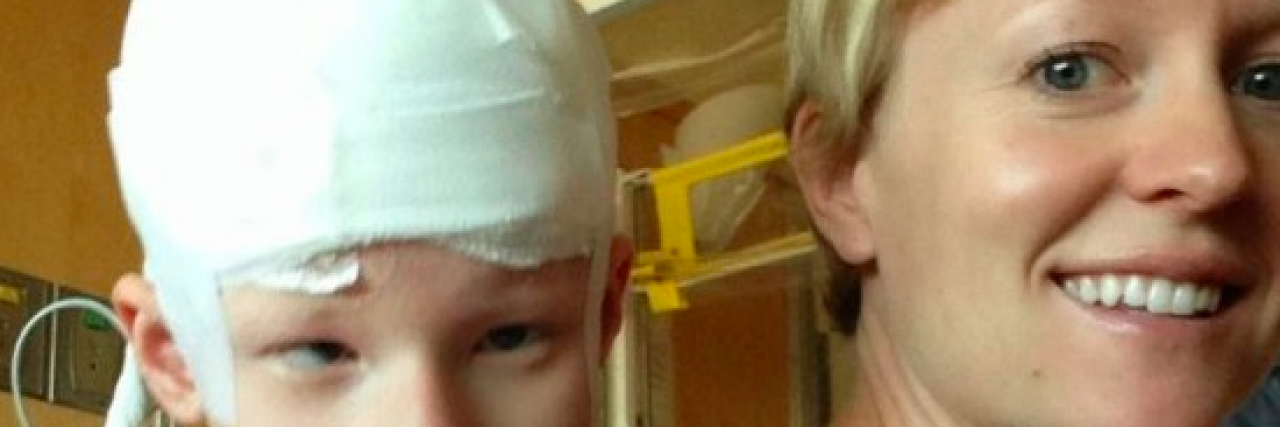 Using Medical Marijuana for Infantile Spasms Mother carrying daughter (girl with head wrapped in bandages) on her back at hospital