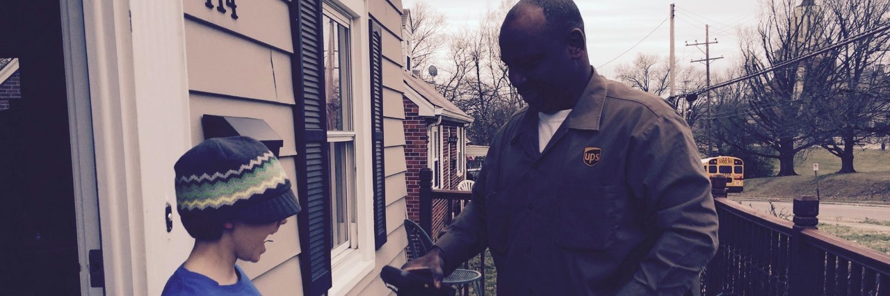 UPS Driver Befriends Young Boy With Autism ups delivery man hands a package to a young boy