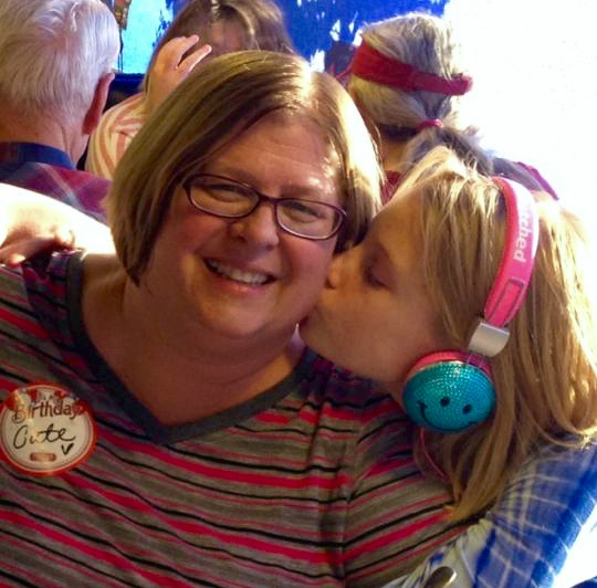 daughter kisses mother on the cheek