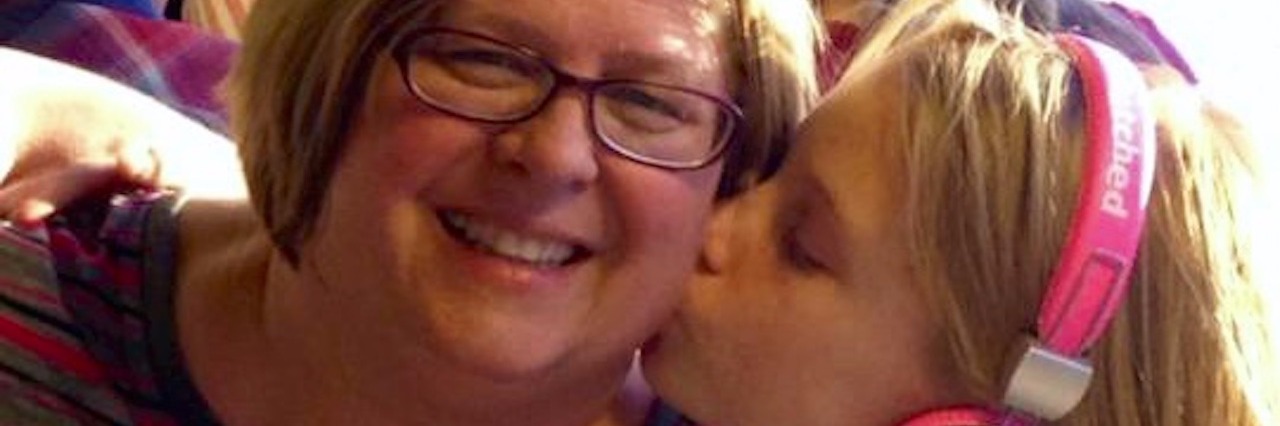 daughter kisses mother on the cheek