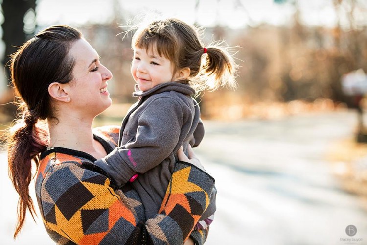 mother holding young girl outdoors