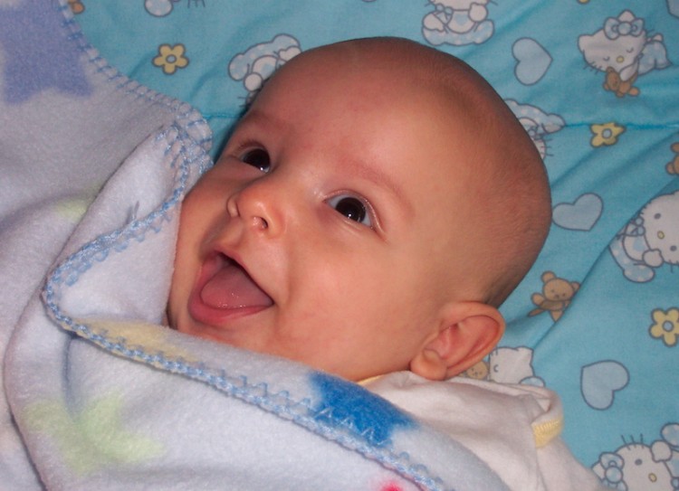 The author's son, smiling with a star-covered blanket