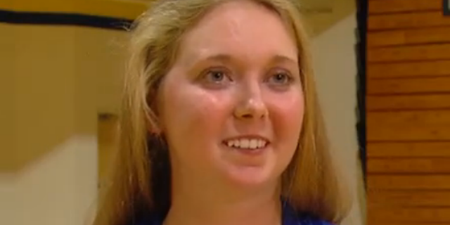 young woman in blue jacket smiling