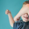 boy with arm over his face
