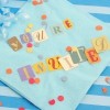 napkin at party with colorful text saying 'you're invited'