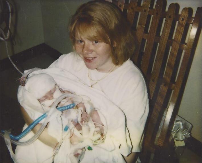 becky holding her daughter with a ventilator