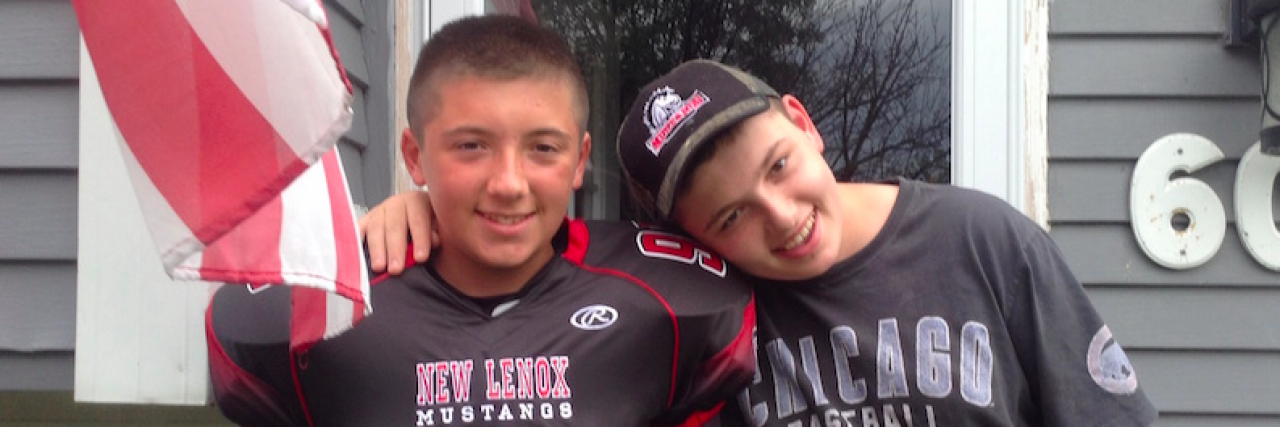 Thinking About My Special Needs Child as the 'Sick Kid' Two boys with arms around each other, one in a football jersey, smiling and standing outside house