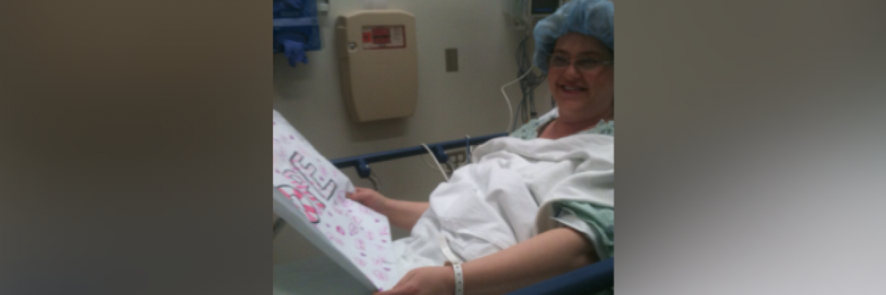 The Sign I Made for a Friend’s Mom Who Had Cancer and Her Response Woman in hospital bed holding a sign and smiling