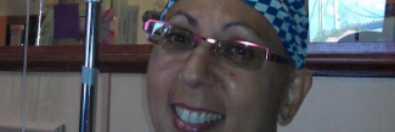 25 Pieces of Advice for Anyone Going Through Chemo Contributor smiling and wearing scarf on her head while in a hospital room