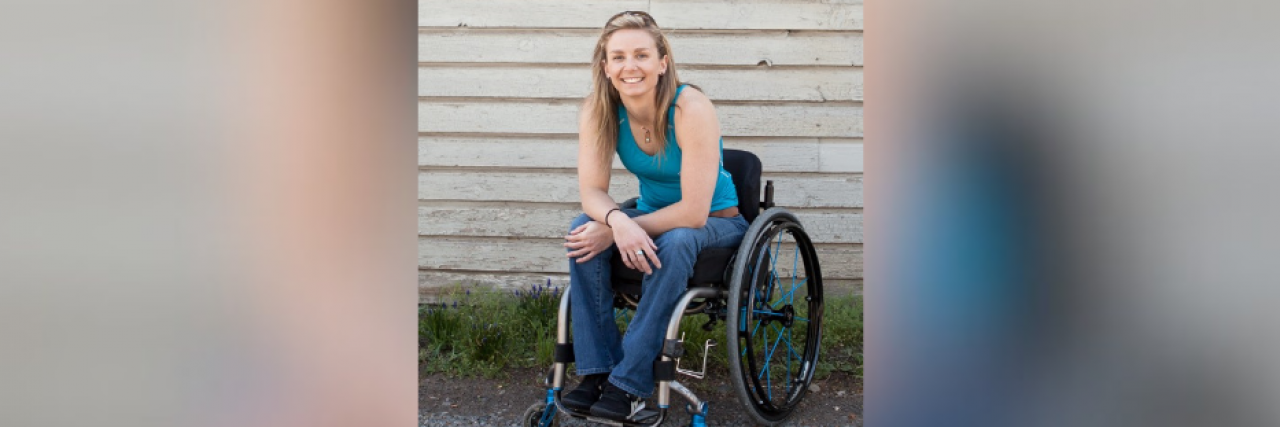 Woman in wheelchair smiling with arms crossed casually